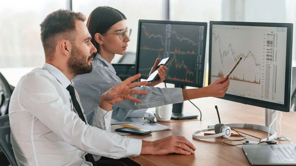 Business people analyzing data on screens